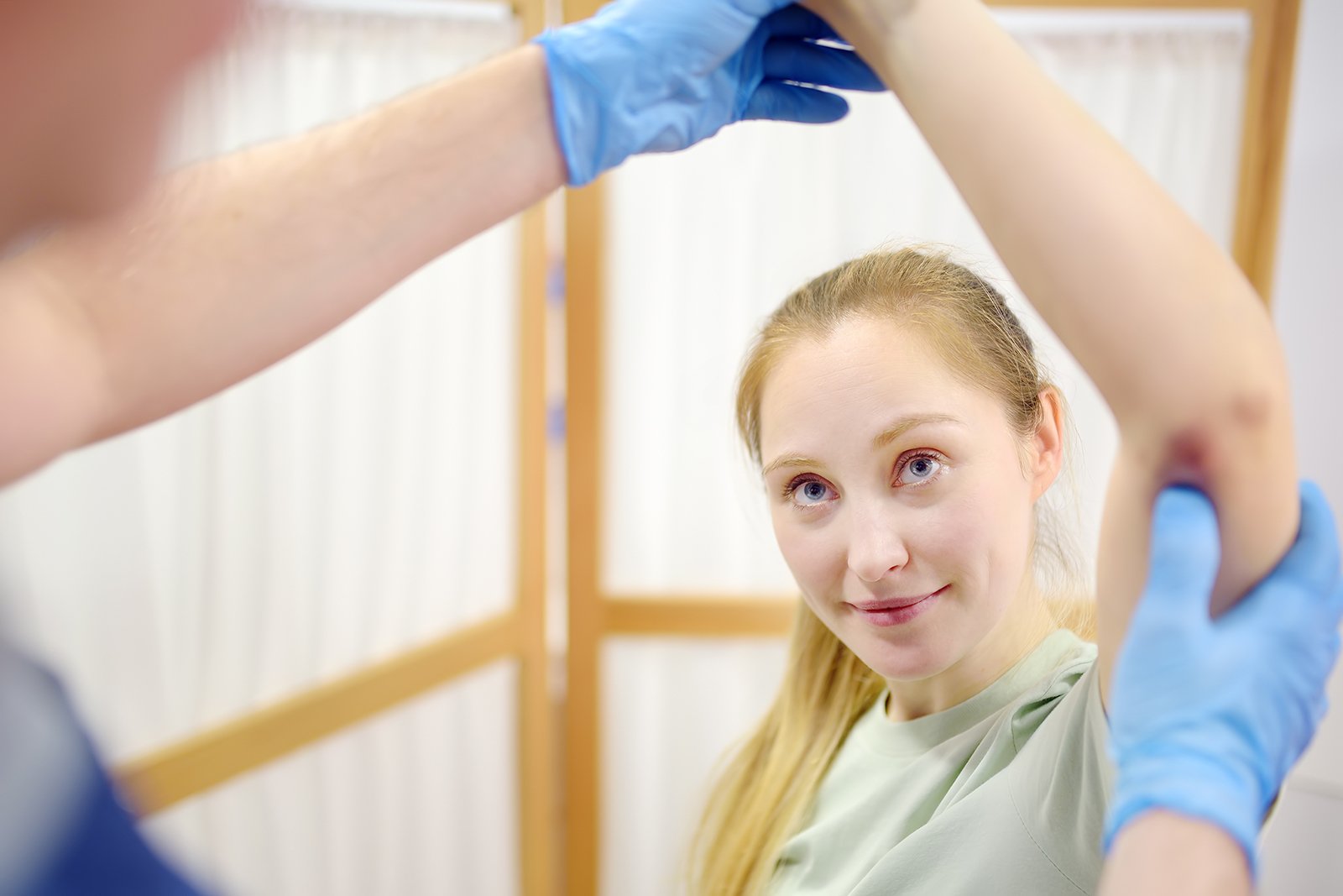 Kinesiologist guiding a patient through a cable-assisted leg stretch