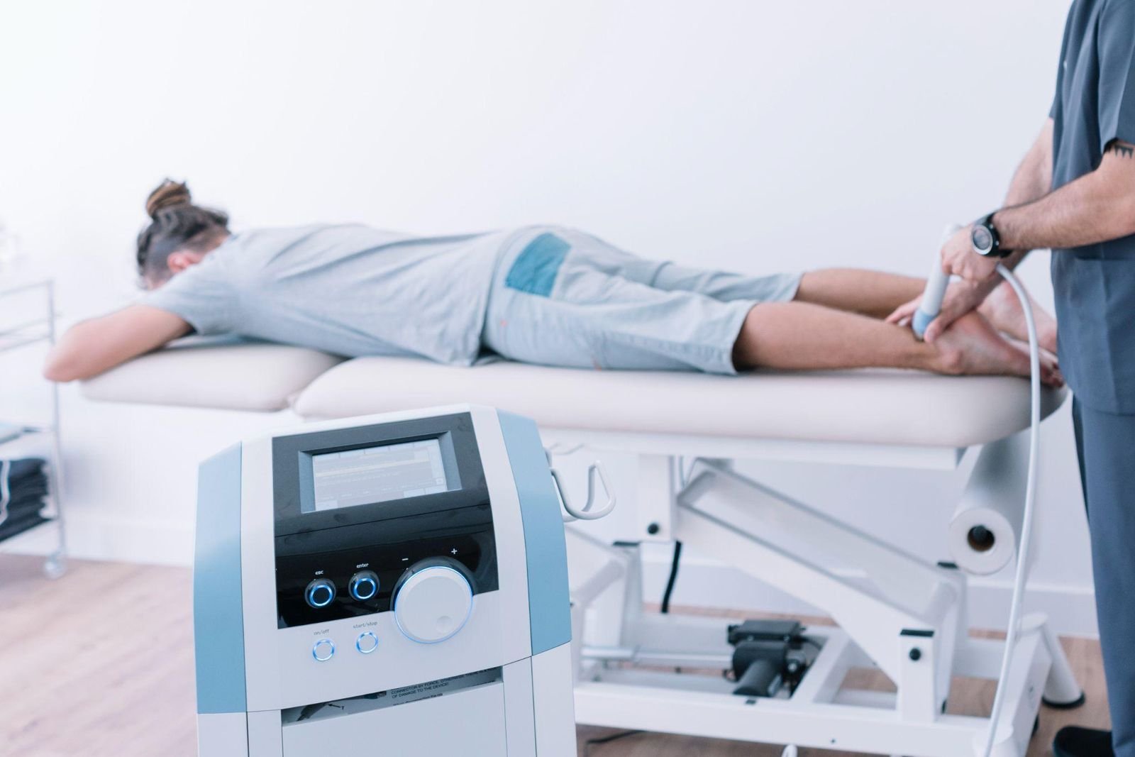 Therapist delivering shockwave therapy to a patient’s lower leg