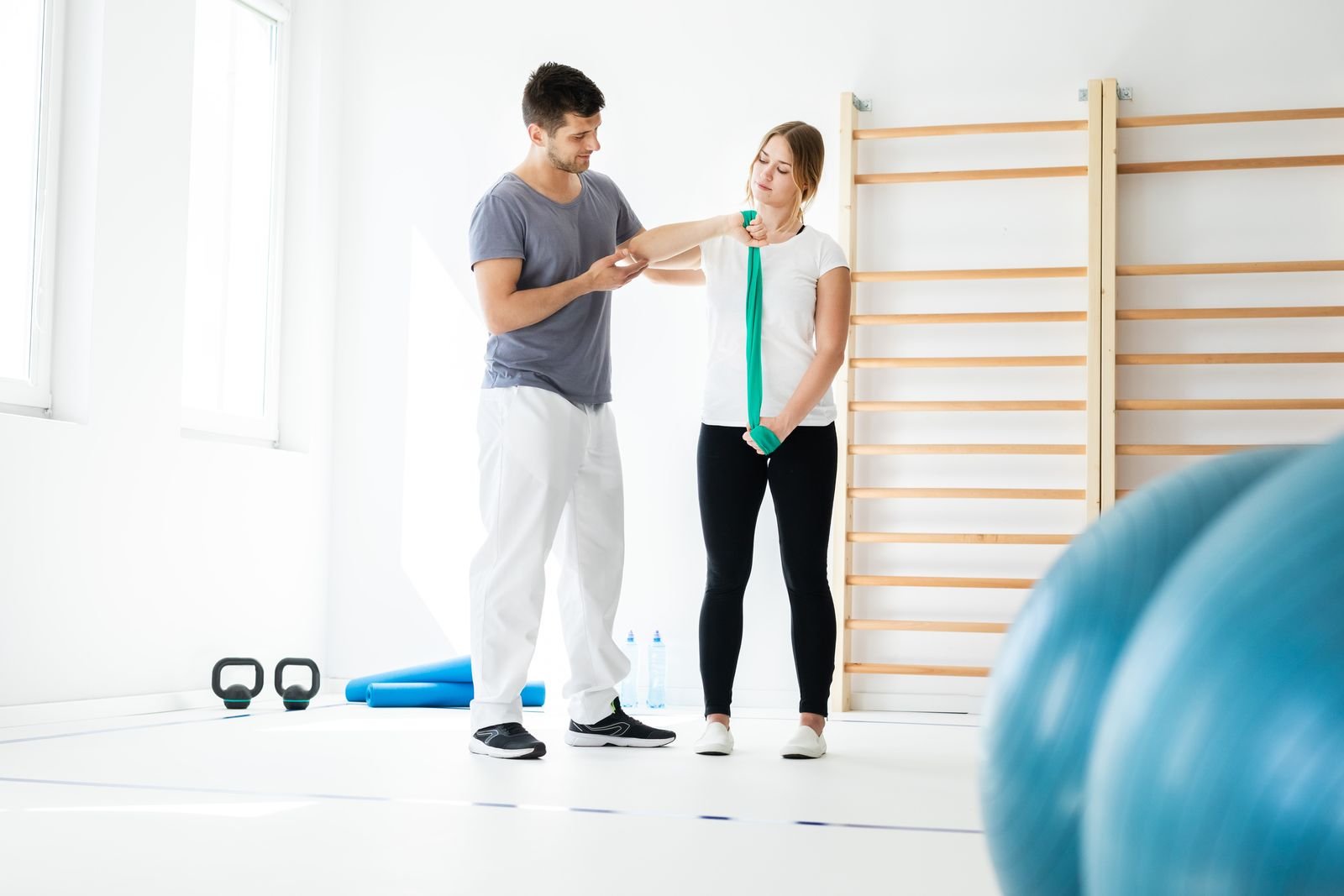 Physiotherapist coaching a patient through a resistance-band exercise