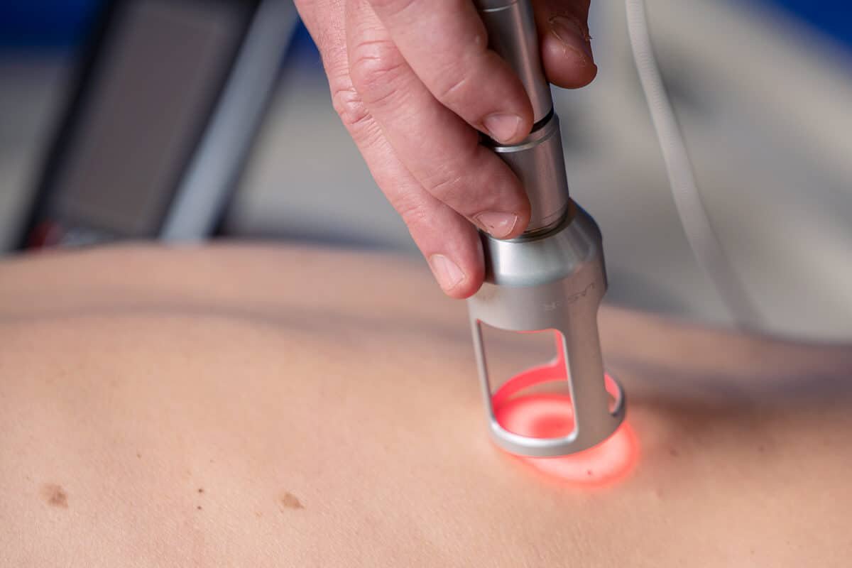 Therapist applying Class IV laser therapy to a patient’s wrist